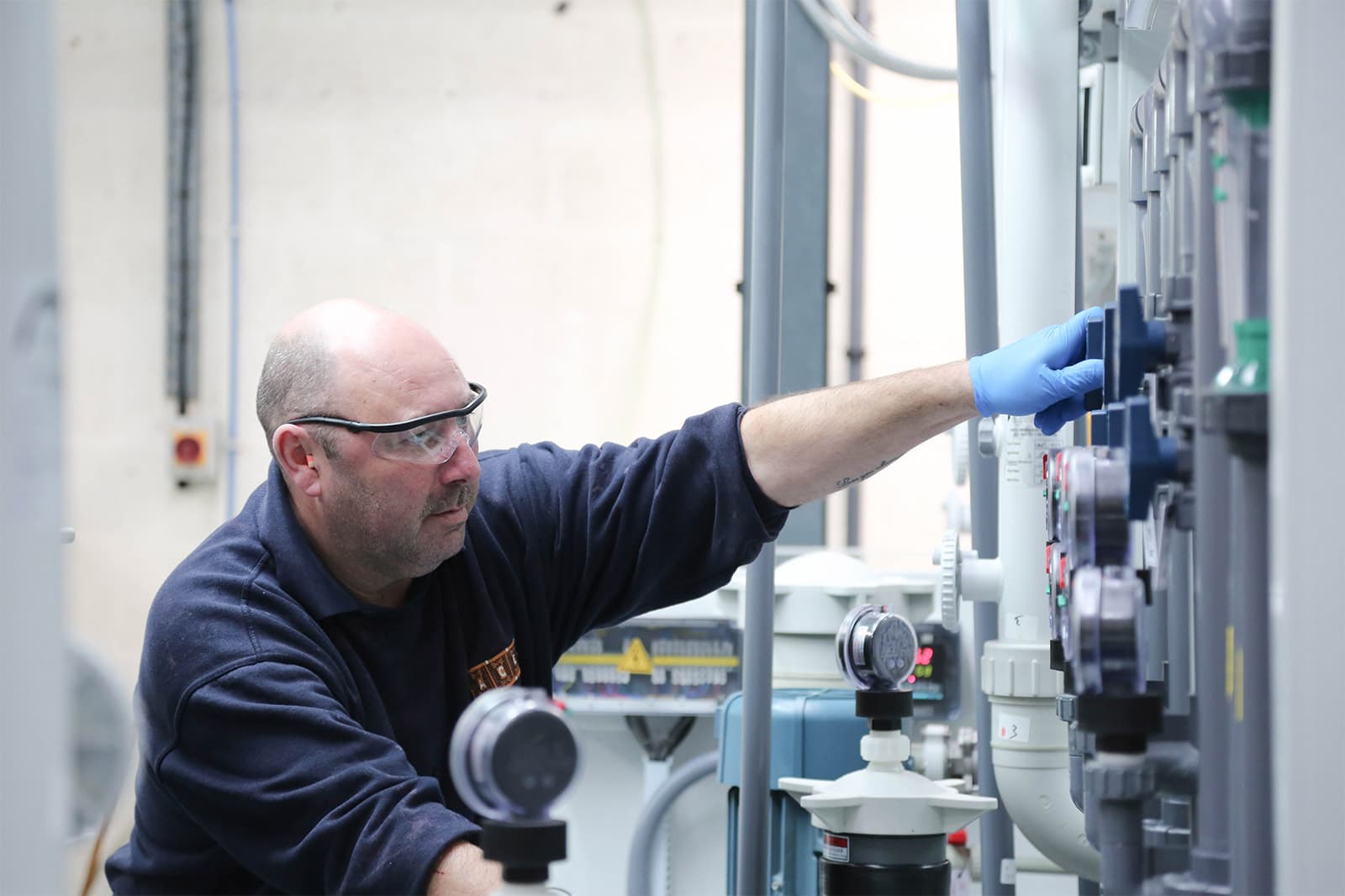 A man adjusts the pressure on a photo etching machine